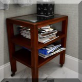 F20. Small tiered glass side table on casters. 